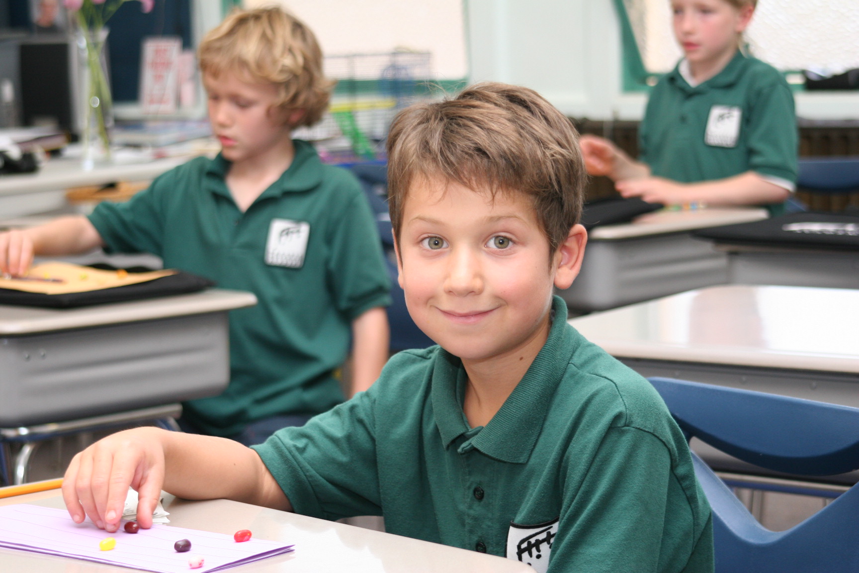 Boys in choir music education class. Wearing matching green polos shirts with printed logo for Pacific Boychoir Academy in Oakland (East Bay), California